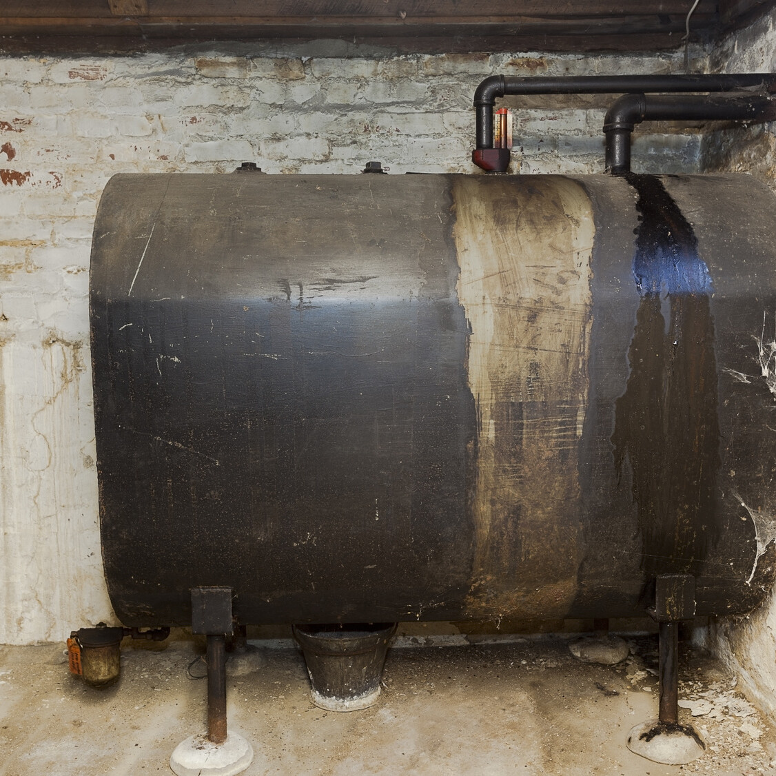 Old heating oil tank in dingy dank basement.