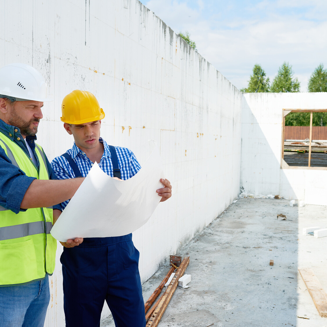 Construction Worker Discussing Floor Plans with Supervisor