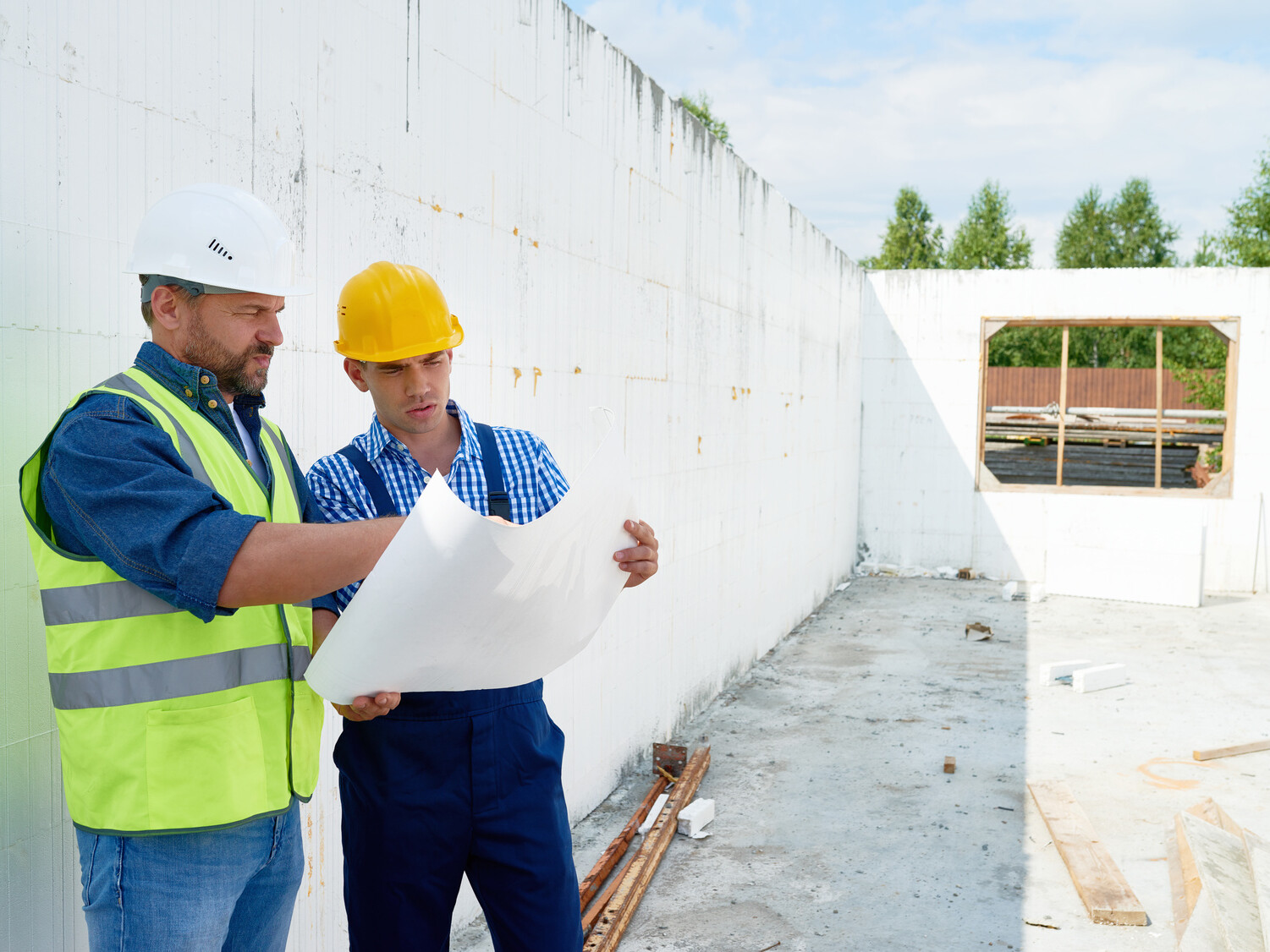 Construction Worker Discussing Floor Plans with Supervisor