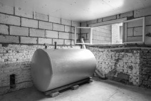 heating oil tank in basement in black and white