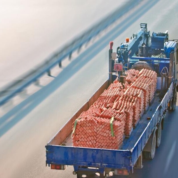 blue truck safely delivering materials for construction