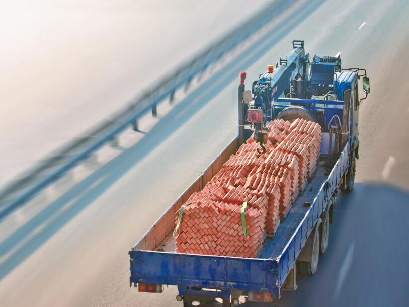 blue truck safely delivering materials for construction
