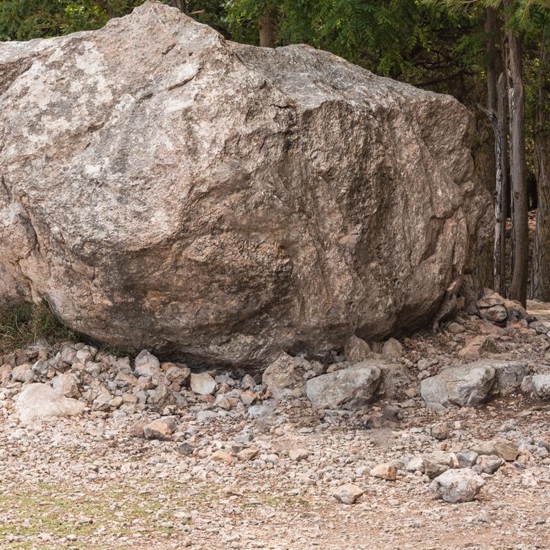 Large boulder with rocks in the woods