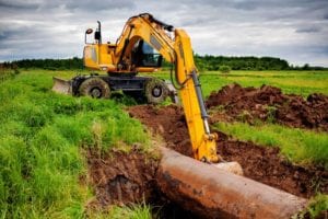 Yellow Construction Excavator performing Commercial Excavation Job