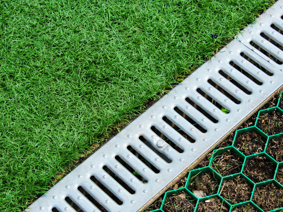 ourdoor drain next to lawn and plot of grass