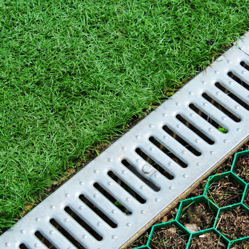 ourdoor drain next to lawn and plot of grass
