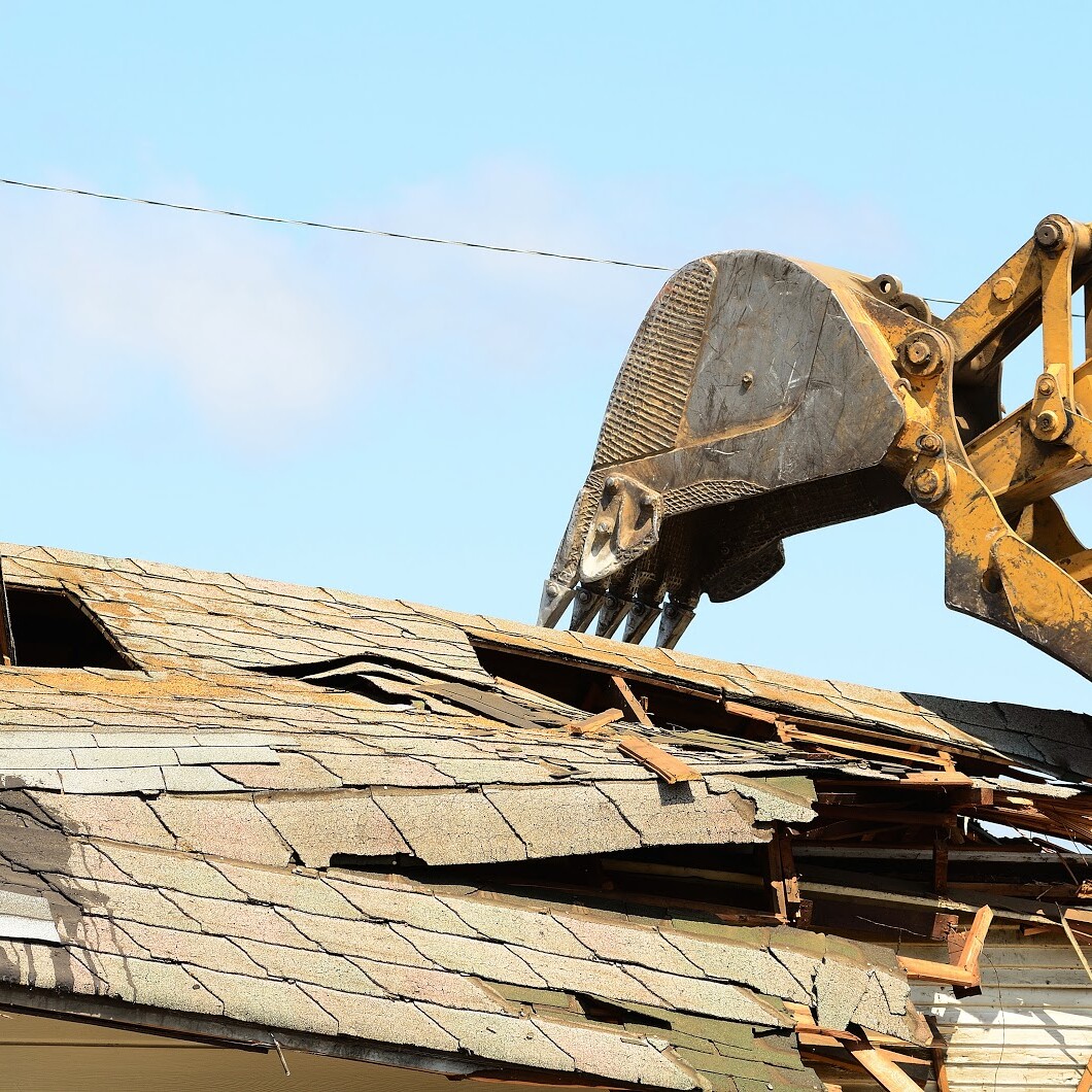 excavator ripping roof off house