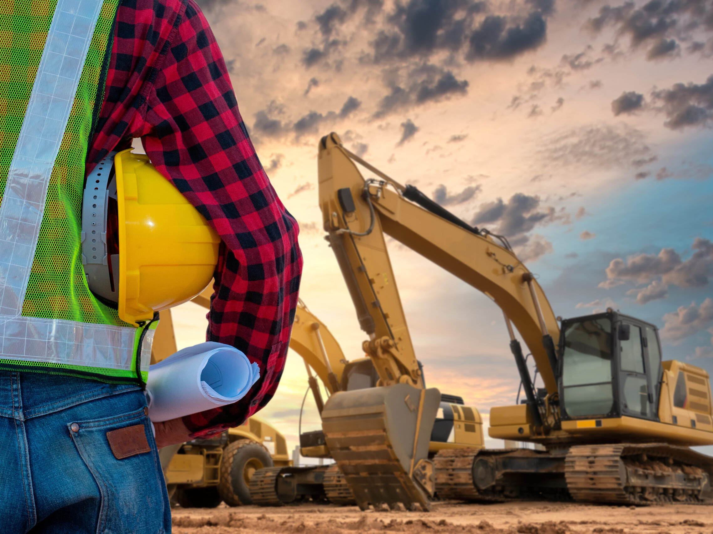 A contractor stands overlooking an excavation site