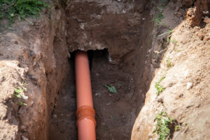 Sewer outlet in the house. Excavated pit and canal in the foundations of the house
