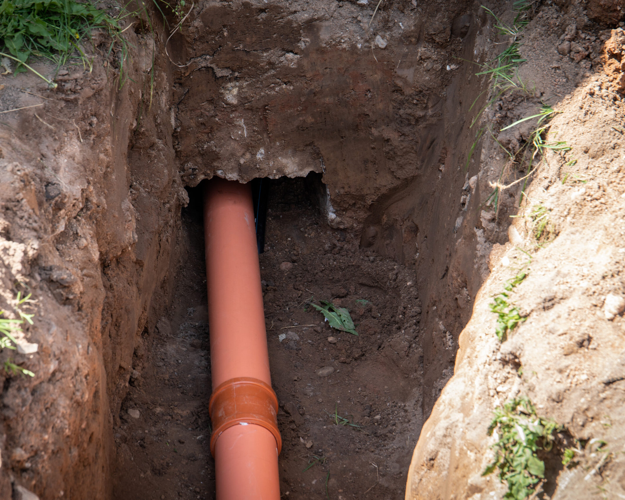 Sewer outlet in the house. Excavated pit and canal in the foundations of the house