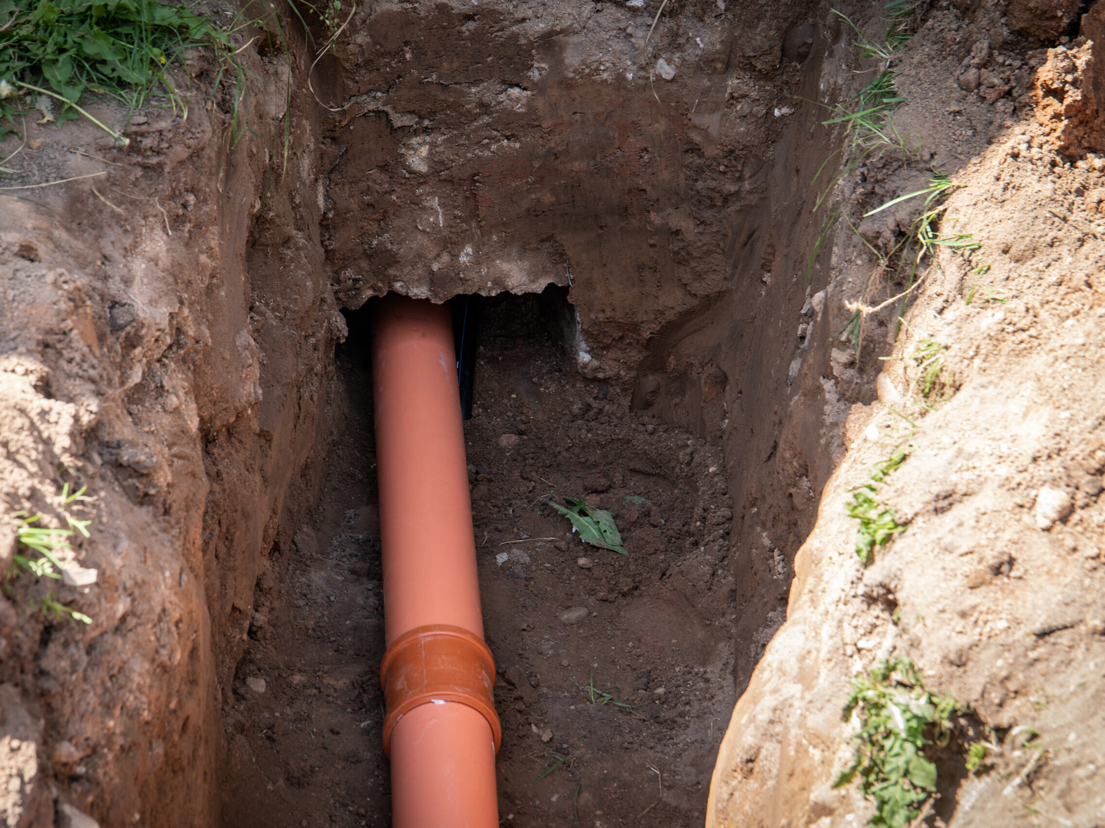 Sewer outlet in the house. Excavated pit and canal in the foundations of the house