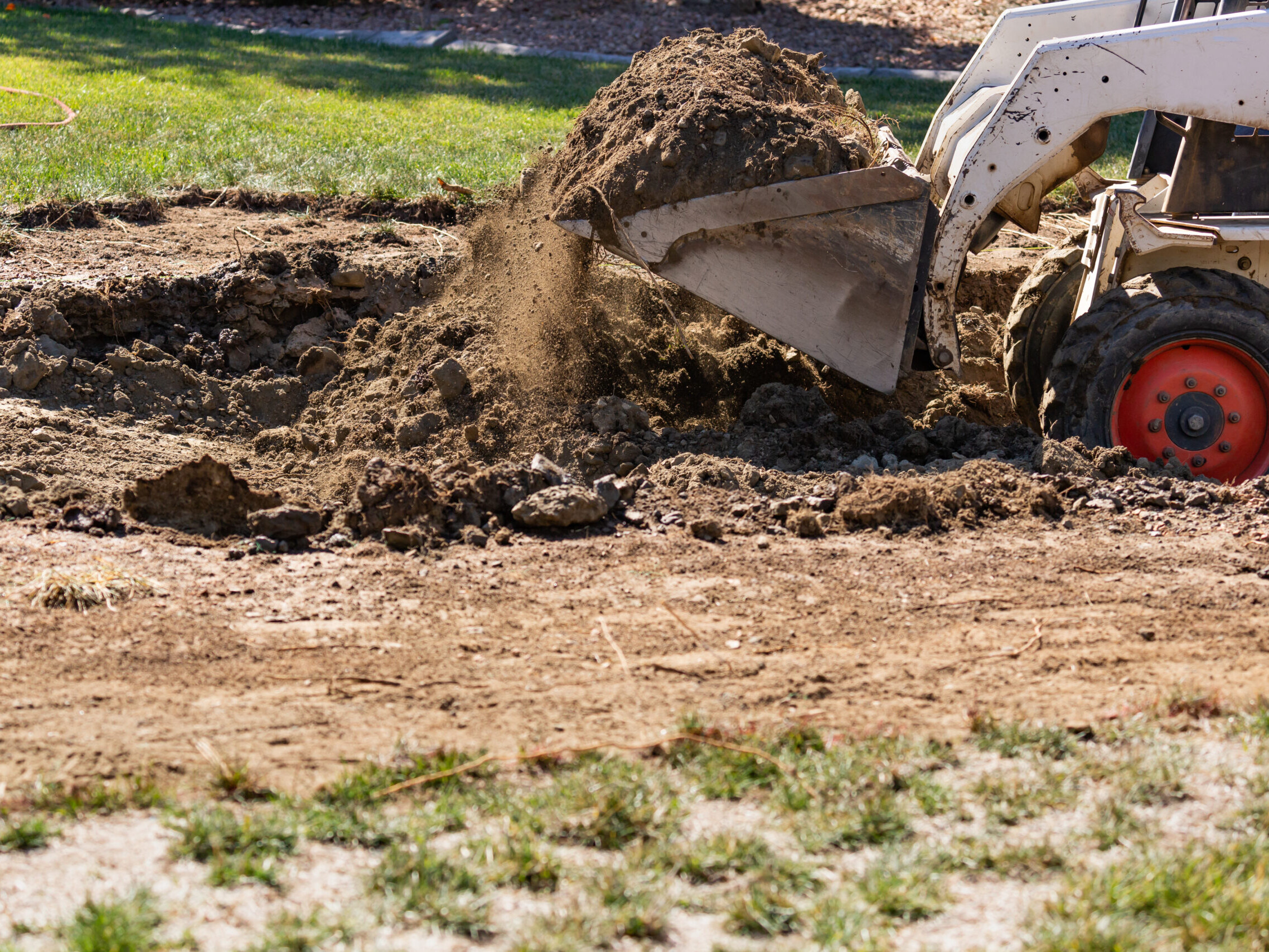 Small Bulldozer Digging In Yard For Pool Installation